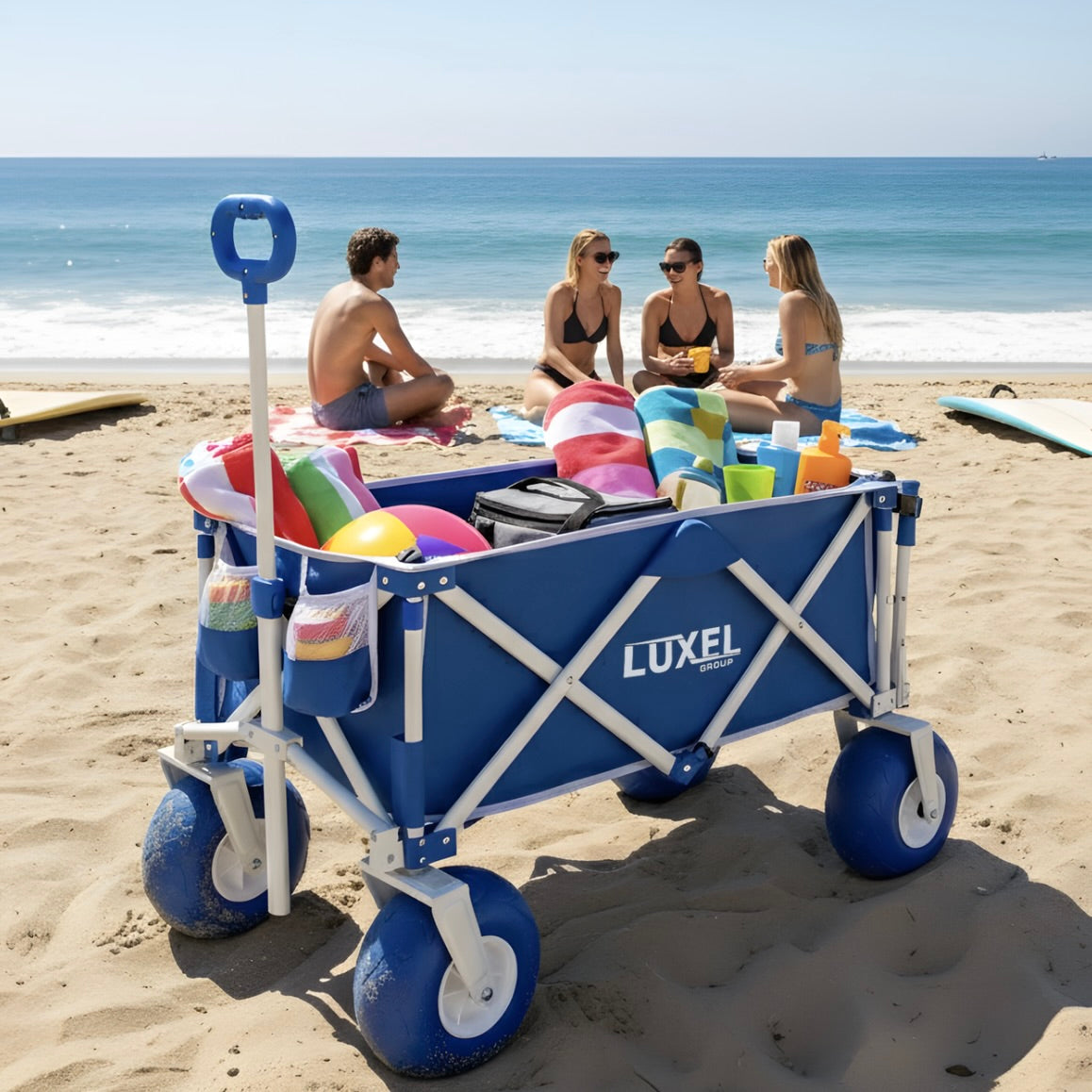 Blue Luxel beach cart with beach gear on a sandy beach