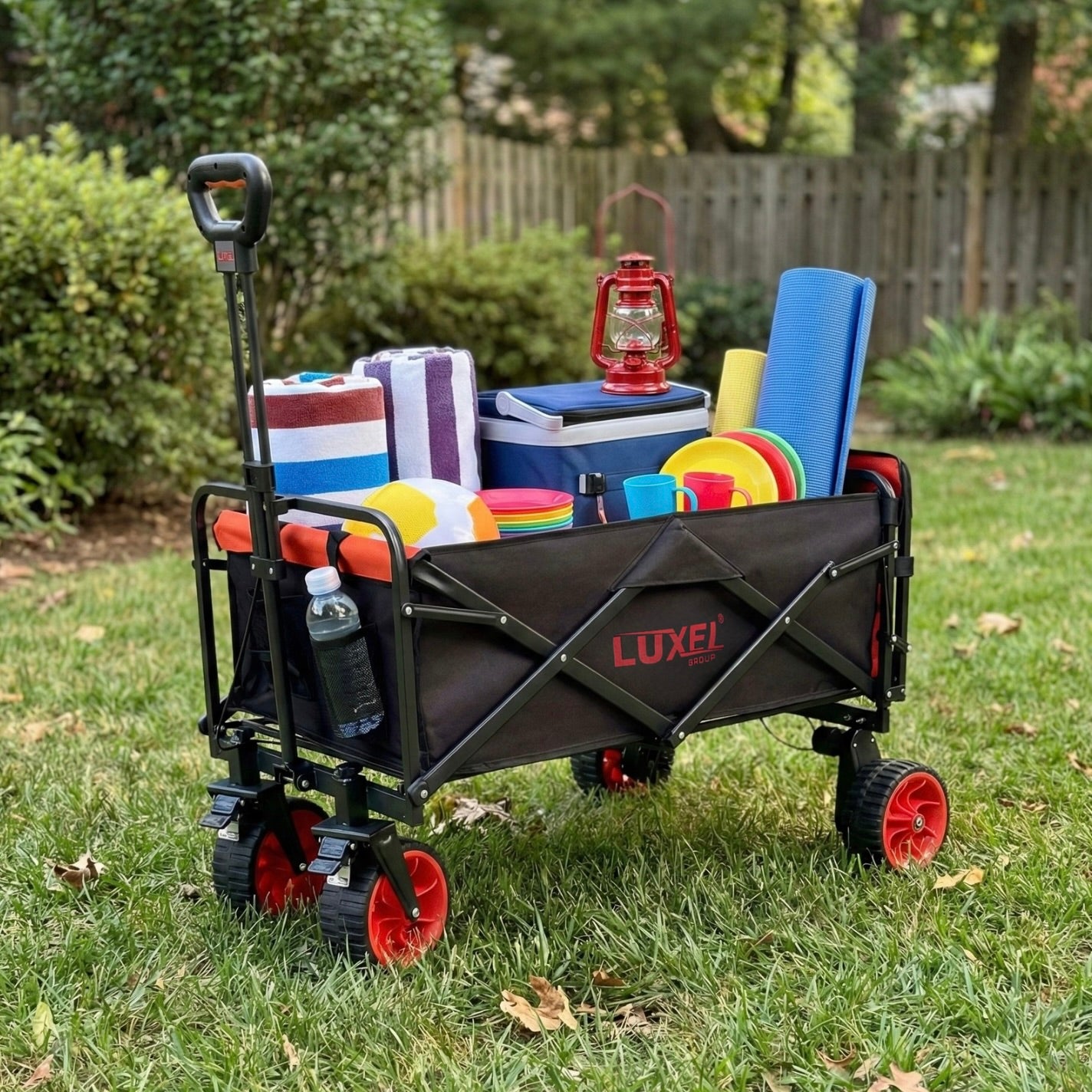 Luxel folding wagon with camping gear on a grassy area