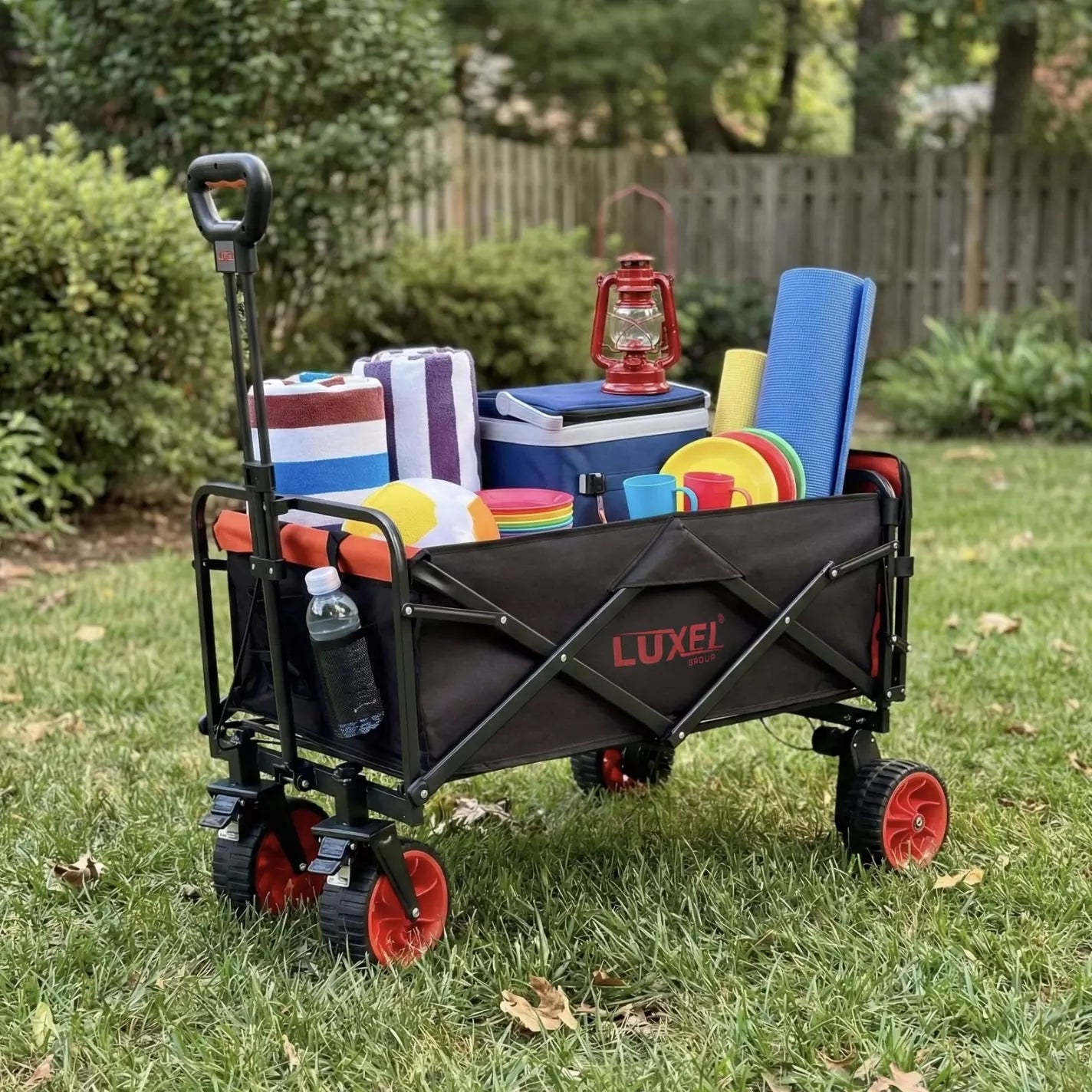 Luxel folding wagon with camping gear on a grassy area