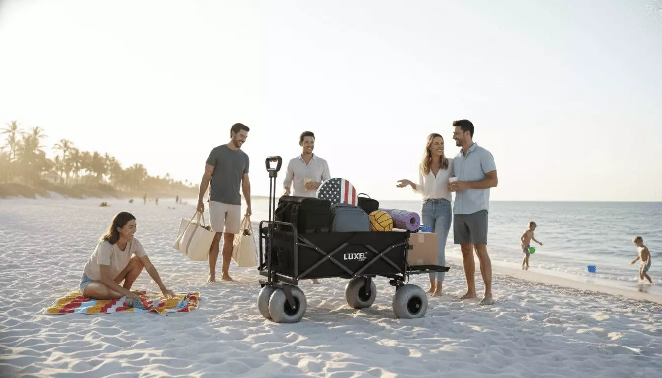 Group of people on a beach with a black wagon, some carrying bags and others sitting or standing.