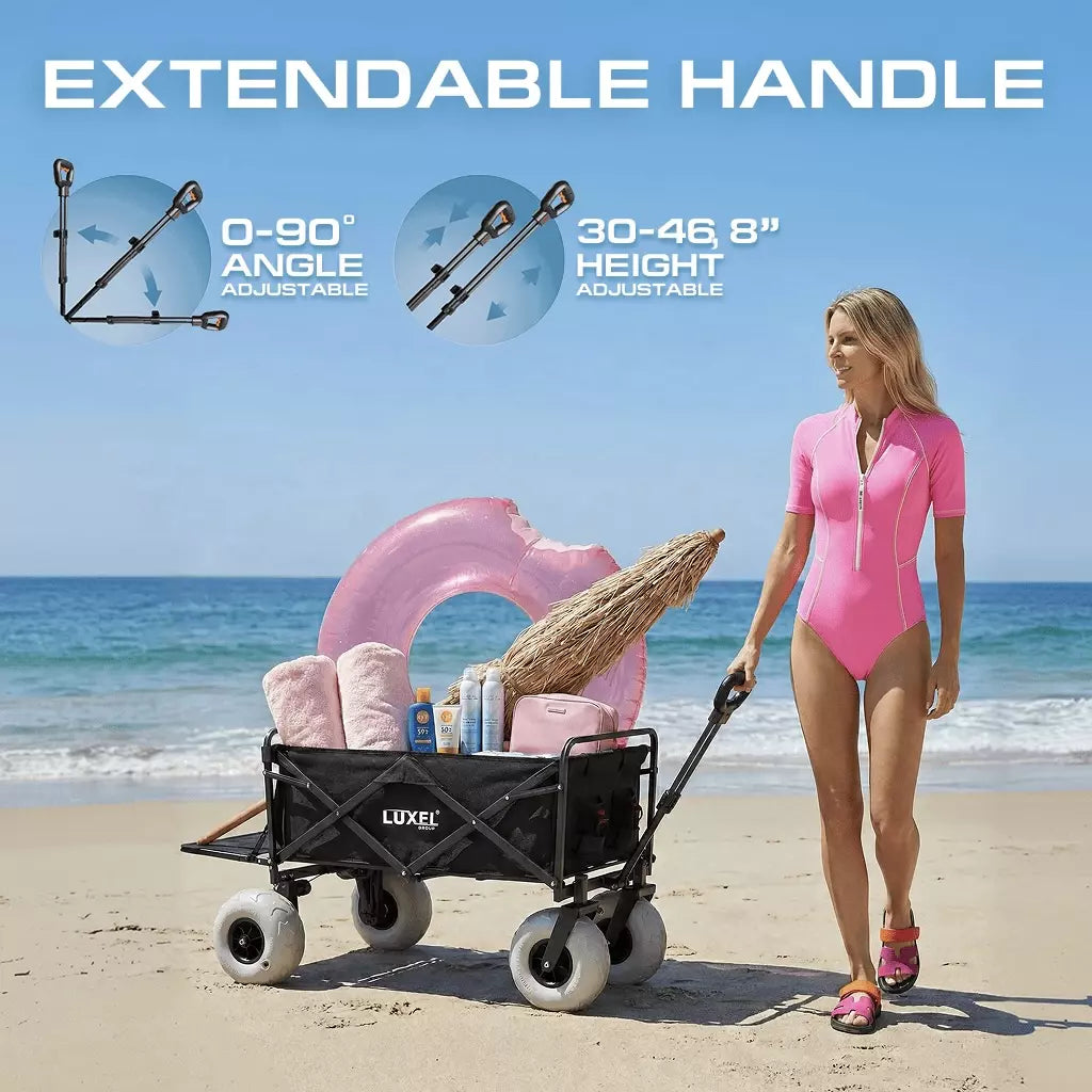 Woman in pink swimsuit pushing a black beach cart with extendable handle on a sandy beach.