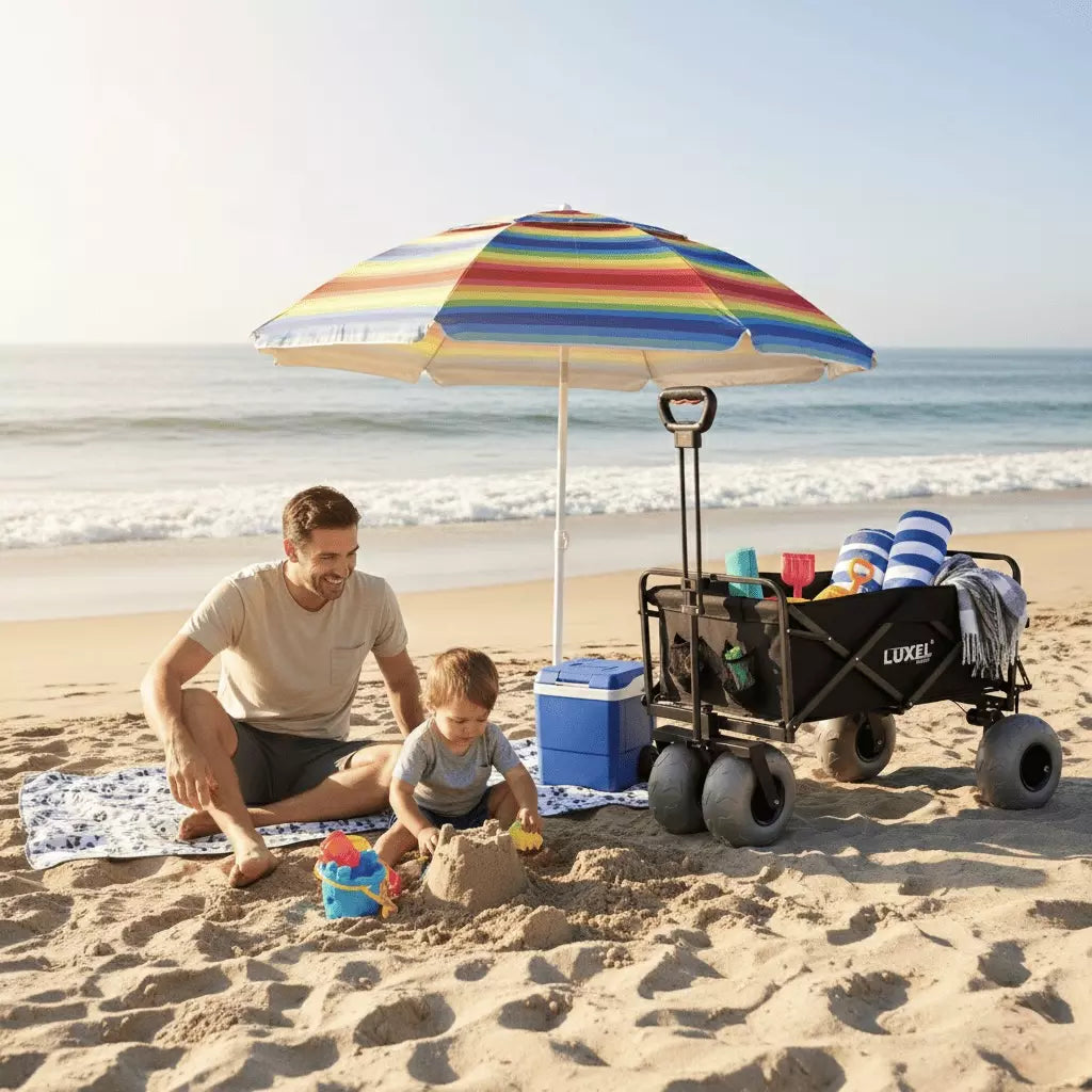 Man and child at the beach with a colorful umbrella, cooler, and wagon.