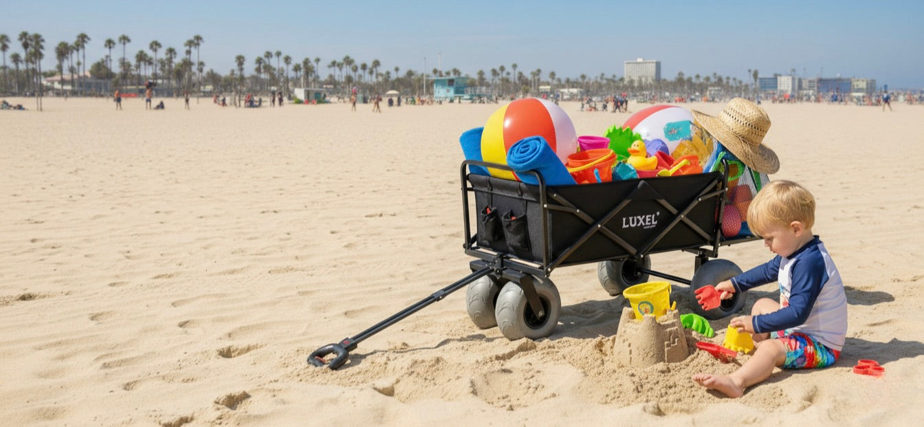 Child playing with a beach wagon full of toys on a sandy beach.